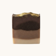 Creation Essential's Natural Body Frankincense & Myrrh honey bar soap with a dark brown gradient and gold shimmer top.