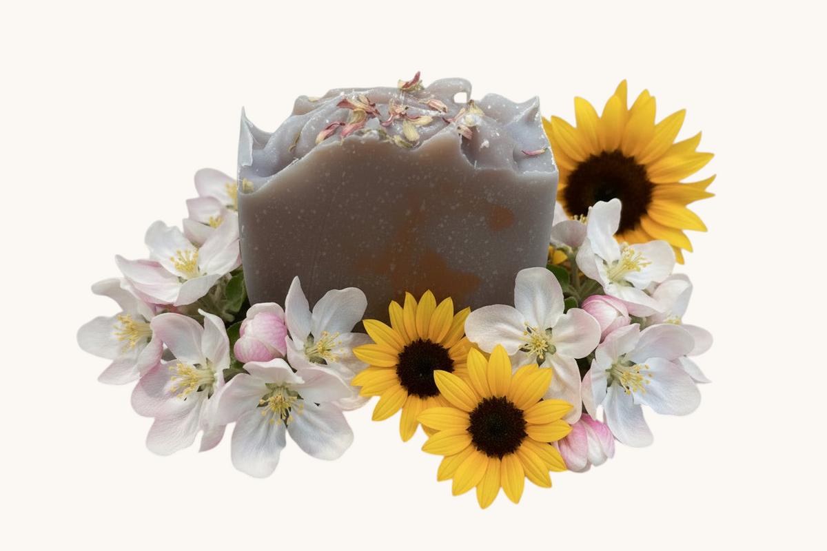 Creation Essential's Natural Body Honey Harvest soap bar topped with dried flowers, surrounded by sunflowers and blossoms