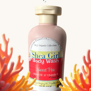 Creation Essential's Natural Body Shea Girl Sweet Pea body wash in a pink bottle surrounded by coral reef decor.