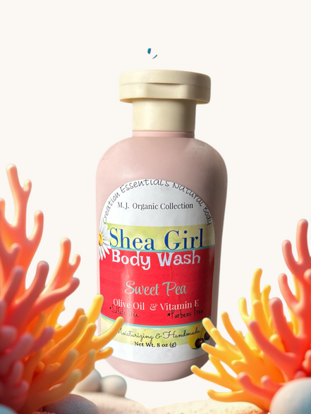 Creation Essential's Natural Body Shea Girl Sweet Pea body wash in a pink bottle surrounded by coral reef decor.