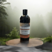 Creation Essential's Natural Body Bay Breeze Tropical Teakwood organic body wash in a 16oz bottle on a wooden stand.