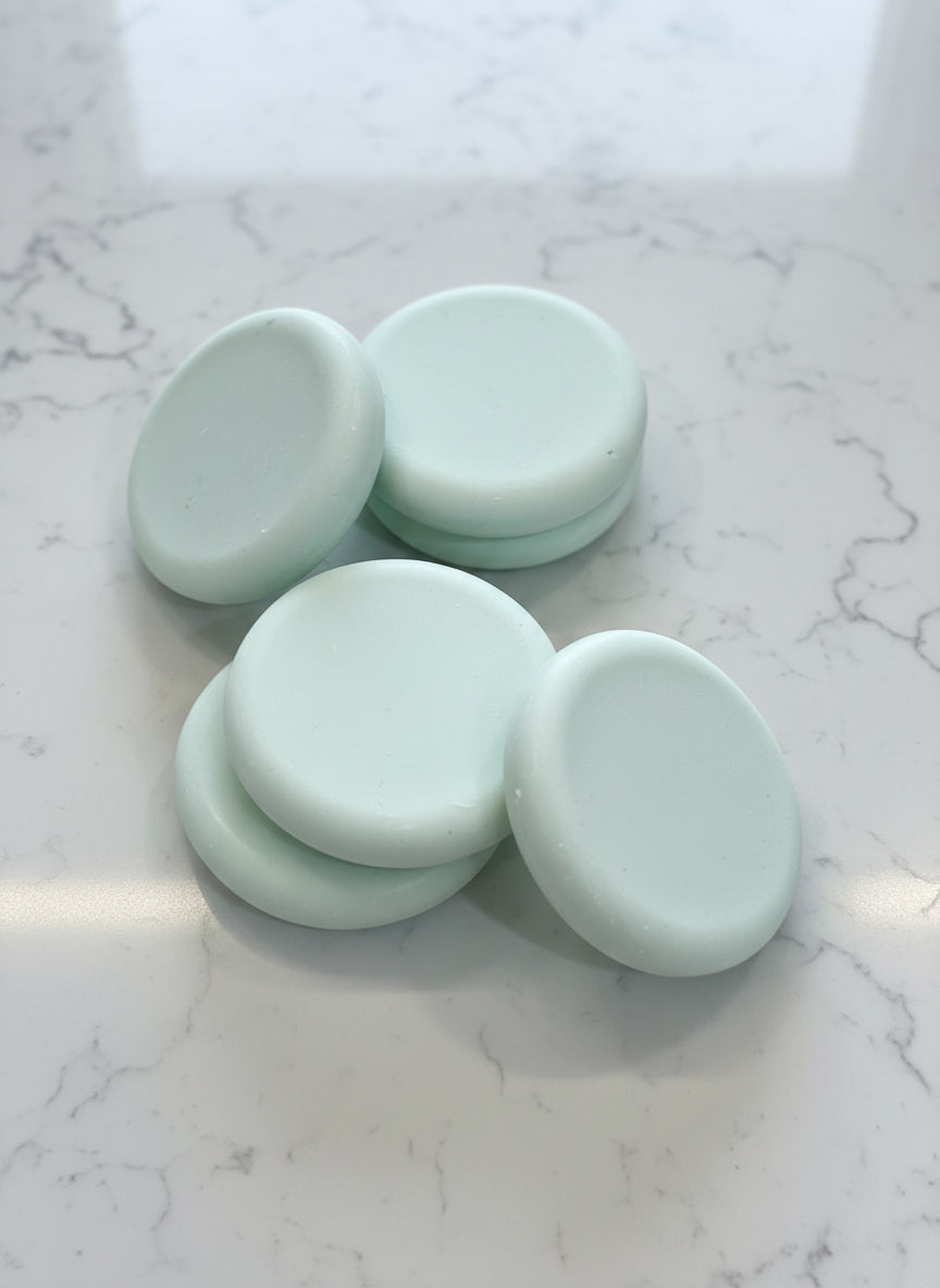 Five light green round soap bars   textured brown surface