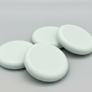 Four round soap bars  on a textured brown surface