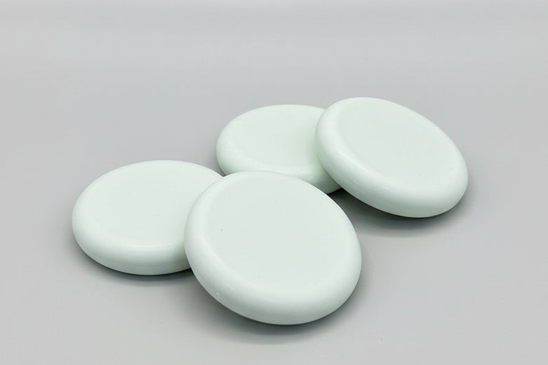 Four round soap bars  on a textured brown surface