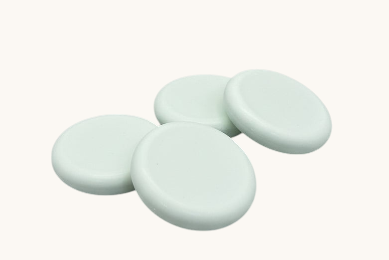Four round soap bars  on a textured brown surface
