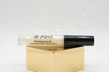Lip impact hydrating lip oil with black cap on a white background