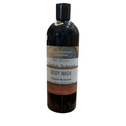 Creation Essential's Natural Body Bay Breeze Tropical Teakwood body wash in a black bottle on a white pedestal