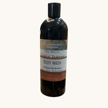 Creation Essential's Natural Body Bay Breeze Tropical Teakwood organic body wash in a 16oz black bottle.
