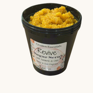 Creation Essential's Natural Body Revive creamy sugar scrub with turmeric and oats in a black jar.