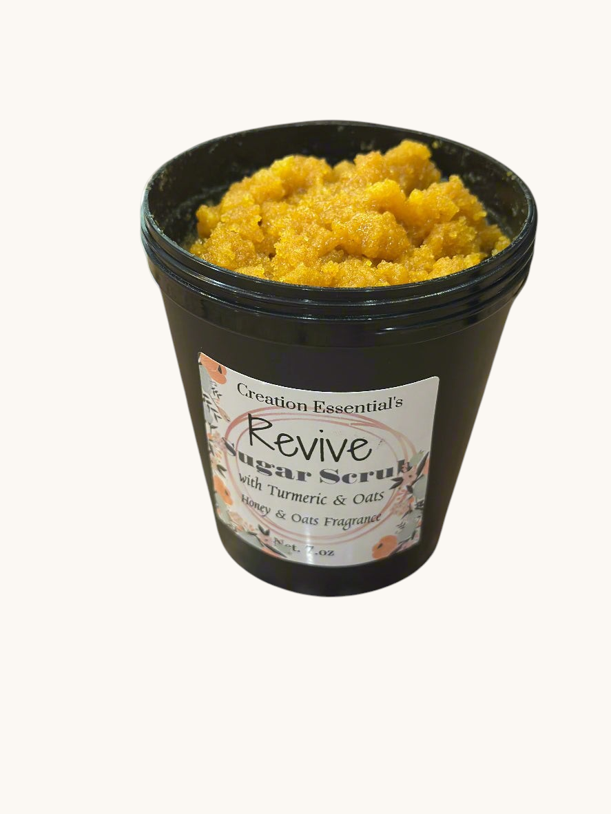 Creation Essential's Natural Body Revive creamy sugar scrub with turmeric and oats in a black jar.