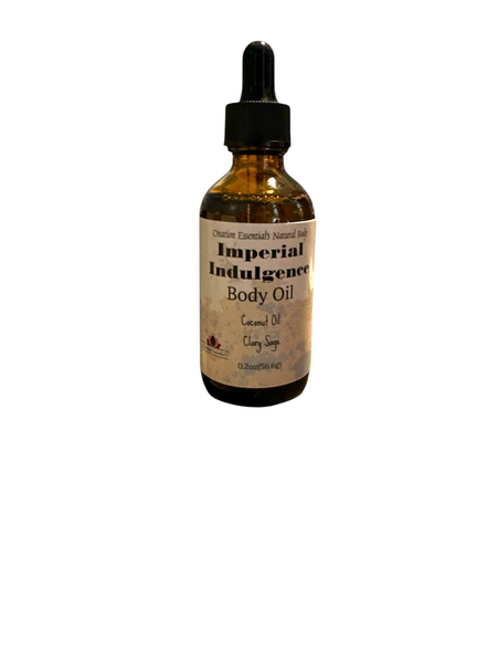 Creation Essential's Natural Body Imperial Indulgence body oil bottle resting on a dark rock above water