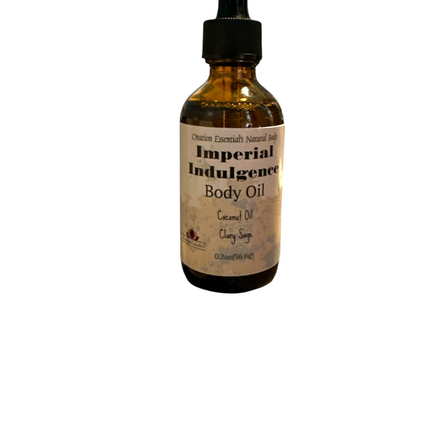 Creation Essential's Natural Body Imperial Indulgence body oil bottle resting on a dark rock above water