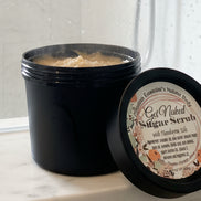 Jar of sugar scrub with a label on a reflective surface