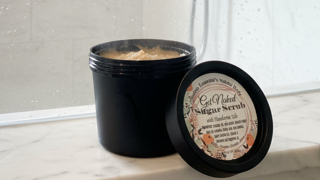 Jar of sugar scrub with a label on a reflective surface