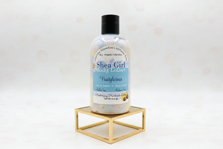 Bottle of Shea Girl body lotion on a gold surface