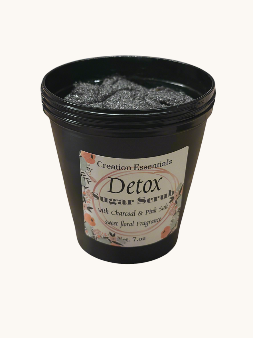 Creation Essential's Natural Body charcoal and pink salt detox body mask scrub in a black jar with floral label