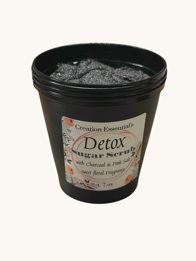 Creation Essential's Natural Body charcoal and pink salt detox body mask scrub in a black jar with floral label