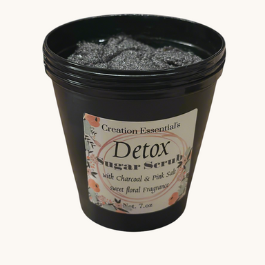 Creation Essential's Natural Body charcoal and pink salt detox body mask scrub in a black jar with floral label