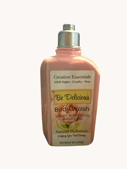 Creation Essential's Natural Body Be Delicious body wash in a pink bottle with rose and almond oil ingredients