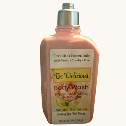 Creation Essential's Natural Body Be Delicious body wash in a pink bottle with rose and almond oil ingredients