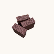 Creation Essential's Natural Body Sweet Harvest bar soap with a textured honeycomb top on a light green background.