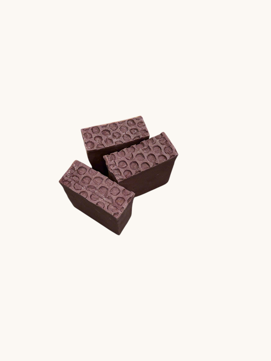 Creation Essential's Natural Body Sweet Harvest bar soap with a textured honeycomb top on a light green background.
