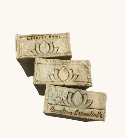 Creation Essential's Natural Body Carrot Delight bar soap with a lotus flower logo embossed on the surface.