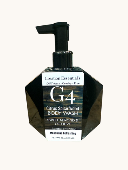 Creation Essential's Natural Body G4 citrus spice wood body wash in a black geometric pump bottle on a marble surface.