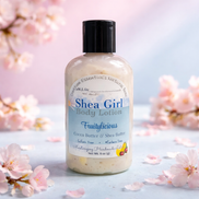 Shea Girl body lotion bottle with cherry blossoms in the background