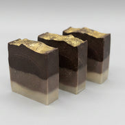 Three layered soap bars on a speckled countertop