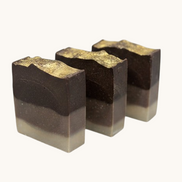 Three layered soap bars on a speckled countertop