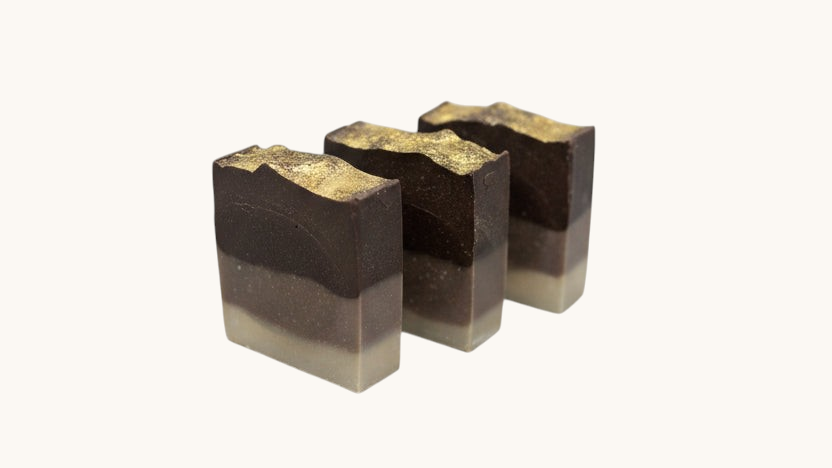 Three layered soap bars on a speckled countertop