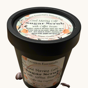 Creation Essential's Natural Body Good Morning Cafe creamy coffee bean sugar scrub in a black jar with scattered beans