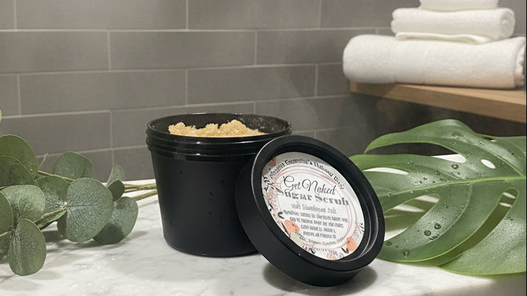 Jar of sugar scrub with a label on a reflective surface