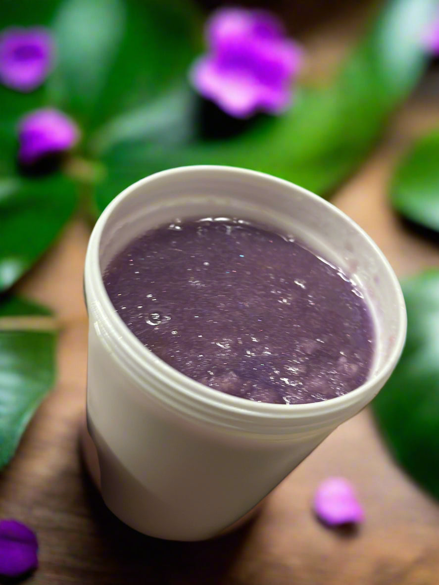 Hand holding a white container with purple Sugar Scrub 