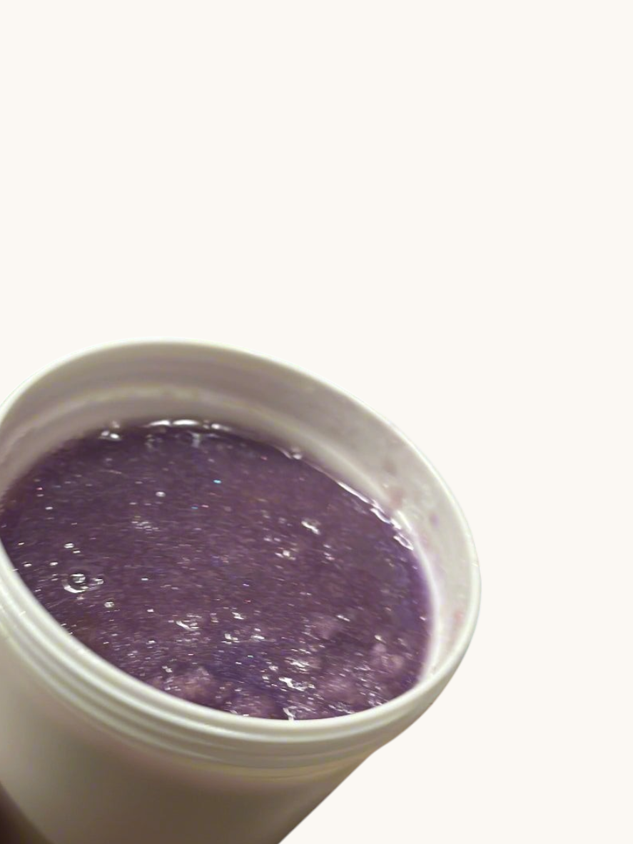 Hand holding a white container with purple Sugar Scrub