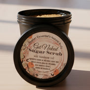 Jar of sugar scrub with a label on a reflective surface