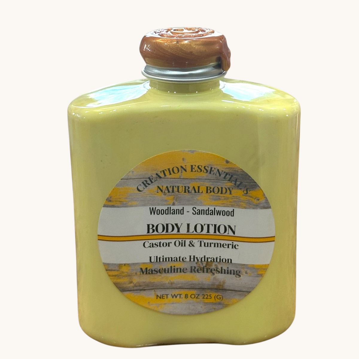 Creation Essential's Natural Body Woodland Sandalwood men's body lotion in a yellow bottle with a wax-sealed cap.