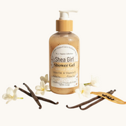 Shea Girl Shower Gel bottle with vanilla beans and flowers on a light background