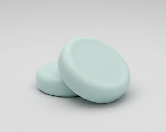  round soap bars  on a textured brown surface