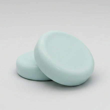  round soap bars  on a textured brown surface