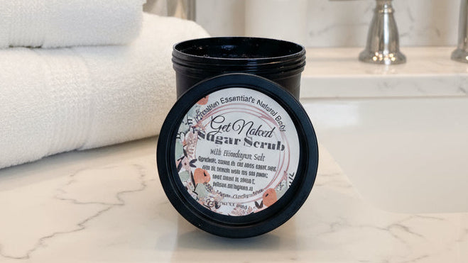 Jar of sugar scrub with a label on a cluttered background