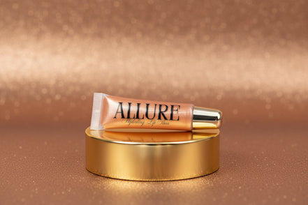 Lip gloss tube with 'Allure' branding on a marbled surface
