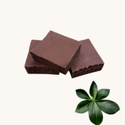 Creation Essential's Natural Body Sweet Harvest red clay bar soap with textured edges on a white marble background.