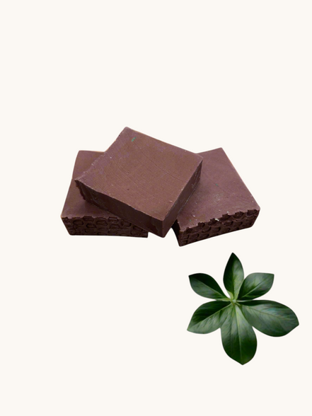 Creation Essential's Natural Body Sweet Harvest red clay bar soap with textured edges on a white marble background.