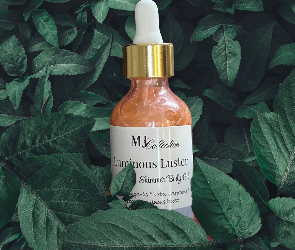 Creation Essential's Natural Body Luminous Luster shimmer body oil in a glass dropper bottle nestled in green leaves