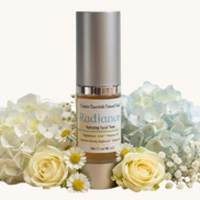 Creation Essential's Natural Body Radiance Hyaluronic Facial Toner bottle surrounded by white hydrangeas and roses.