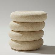 Stack of round, beige objects on a glass surface with a blurred background