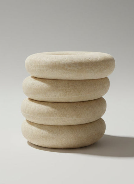 Stack of round, beige objects on a glass surface with a blurred background