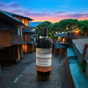 Creation Essential's Natural Body Bay Breeze Tropical Teakwood organic body wash in a 16oz bottle on a stone path